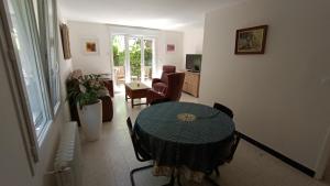 Habitación con mesa, sillas y sala de estar. en Grand appartement, 2 chambres et jardin, en Nimes