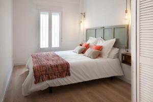 a bedroom with a large white bed with red pillows at Hispalis plaza de la Alameda de Hércules in Seville