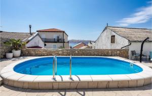 a large swimming pool in a patio with a stone wall at 3 Bedroom Awesome Home In Karlobag in Karlobag