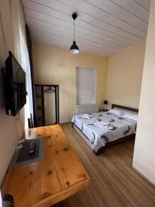 1 dormitorio con cama, mesa y TV en Villa Mestia Hotel en Mestia