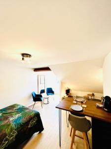 - une chambre avec un lit, une table et des chaises dans l'établissement Le Bellevue, à Barcelonnette