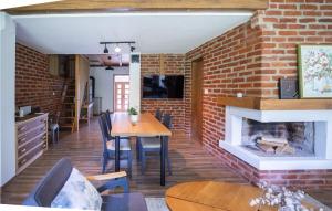 a dining room with a brick wall and a fireplace at Awesome Home In Rokovci With Outdoor Swimming Pool 
