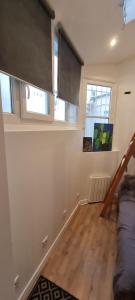 Cosy Studio in Montmartre في باريس: غرفة معيشة مع أريكة ونوافذ