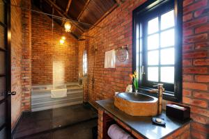 a bathroom with a stone sink and a brick wall at ENSO Retreat Hoi An in Hoi An