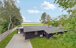 a small black house with a patio and grass at Lovely Home In Jgerspris With House Sea View in Jægerspris