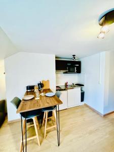eine Küche und ein Esszimmer mit einem Holztisch und Stühlen in der Unterkunft Le Bellevue in Barcelonnette