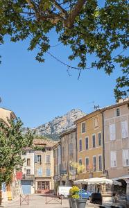 eine Gruppe von Gebäuden mit einem Berg im Hintergrund in der Unterkunft La Terrasse d'Oléa, au coeur du village in Buis-les-Baronnies