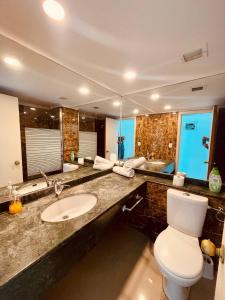 a bathroom with a sink and a toilet and a mirror at Sea Breeze Studios in Netanya
