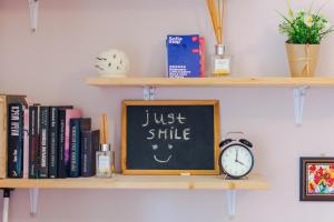 a chalkboard with a just smile sign and a clock at The Top Spot - Cute Little Studio in the Center by Flat Mаnager in Sofia