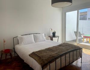 a bedroom with a large bed and a large window at Casa Amiluz in Ponta Delgada