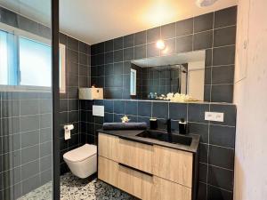 een badkamer met een wastafel, een toilet en een spiegel bij La Villa Océane, Elegante, Plages, GR34, 2-8 pers in Clohars-Carnoët