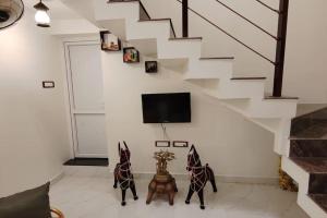 two statues of horses in a living room with a staircase at Day One Studio Apartment in Madurai