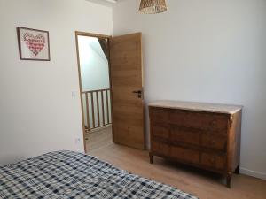 - une chambre avec un lit, une commode et une porte dans l'établissement La clé des champs, à Videlles