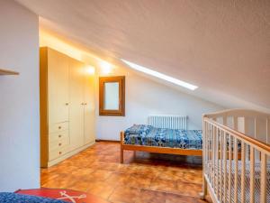 a attic bedroom with a bed and a crib at Spaghetti & Cappuccino Beach Villa in Pella
