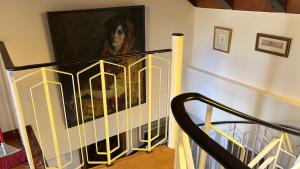 a staircase with a painting of a woman on the wall at Garden Apartment in Baden-Baden