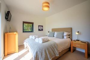 una camera da letto con un letto e asciugamani di Locholly Lodge ad Achiltibuie