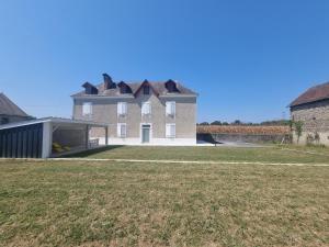 une grande maison avec une pelouse devant elle dans l'établissement Chez Cédric et Mélissa maison Lou Milhòc en Béarn, 