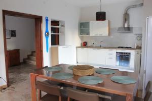 una cocina con una mesa de madera con sillas alrededor. en Lilly's Home en Castelfranco Veneto
