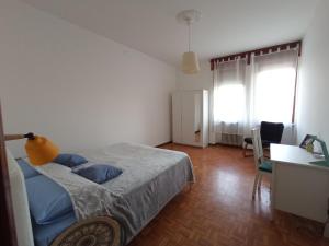 1 dormitorio con cama, escritorio y ventana en Lilly's Home en Castelfranco Veneto