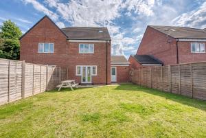 a brick house with a fence and a yard at Luxurious Birmingham Home Private Parking WiFi - near to NEC and QEH in Longbridge