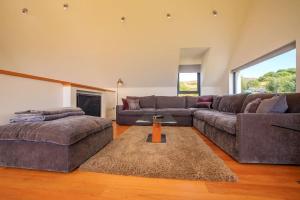 un soggiorno con divano e tavolo di Locholly Lodge ad Achiltibuie