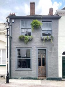 a gray house with windows and a door and a street light at Seasoned Grandeur Home in Faversham