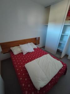 - une chambre avec un lit et une couette rouge et blanche dans l'établissement Appartement 10 personnes au pied des pistes - Superdévoluy, à Superdevoluy