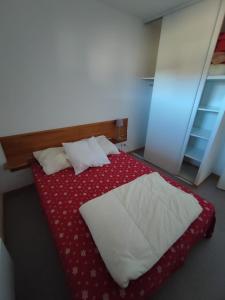 a bedroom with a bed with a red and white comforter at Appartement 10 personnes au pied des pistes - Superdévoluy in Superdevoluy