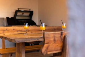 deux verres de jus d'orange assis sur une table en bois dans l'établissement Casa Del Sole, à Vodice