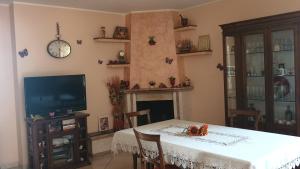 een eetkamer met een tafel, een tv en een open haard bij Villa Sabrina in Castro dei Volsci