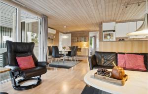 BjerregårdにあるBeautiful Home In Hvide Sande With Wifiのリビングルーム(ソファ、椅子、テーブル付)