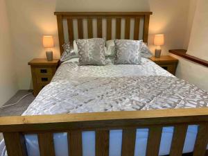a bedroom with a bed with two night stands and two lamps at Logan Beck Farm in Broughton in Furness