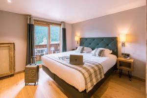 a bedroom with a bed with a laptop on it at Les Gentianettes Hotel & Spa in La Chapelle-dʼAbondance