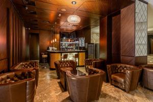 a restaurant with leather chairs and a bar at Khreschatyk Hotel in Kyiv