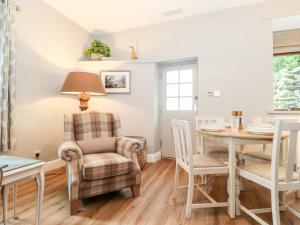 Sala de estar con mesa de comedor, silla y mesa en Gale House Cottage, en Ambleside
