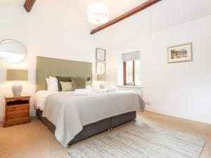 Un dormitorio blanco con una cama grande y una ventana en Gale House Cottage, en Ambleside