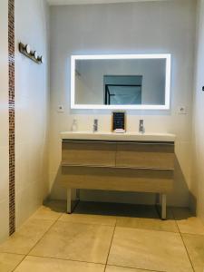 La salle de bains est pourvue d'un lavabo et d'un miroir. dans l'établissement ferme st pierre suite, piscine, clim, repas, cheminée, à Chabeuil