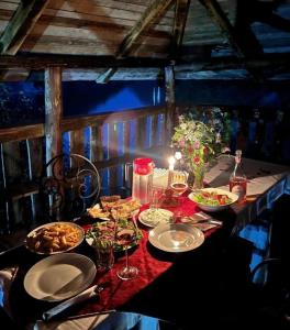 a table with plates of food and glasses of wine at Guest House Aprripe Guri in Fierzë