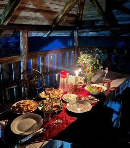 een tafel met borden en glazen wijn bij Guest House Aprripe Guri in Fierzë