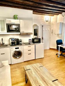 a kitchen with white cabinets and a table at Appartement principal in Paris