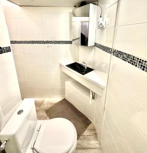a white bathroom with a toilet and a sink at Appartement principal in Paris