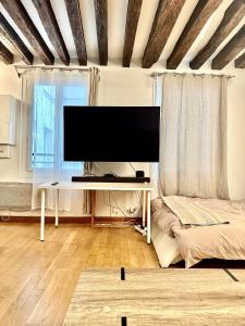 a living room with a flat screen tv on a table at Appartement principal in Paris