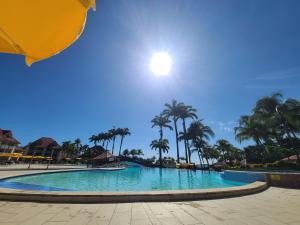 a large swimming pool with palm trees and the sun at studio village vacance sainte luce C5 in Sainte-Luce