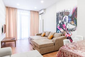 a living room with a couch and a table at Luxury Sweet Home 4 at Freedom Square in Tbilisi City