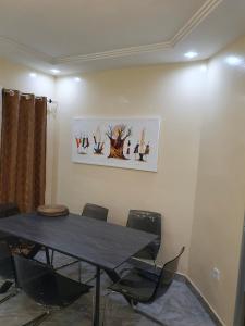 a dining room with a black table and chairs at Maison d'Hôtes entière Cité Douane Golf Dakar in Dakar