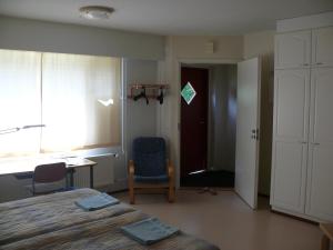 ビッラトにあるHuoneistohotelli DomusVirratのベッドルーム1室(ベッド1台、椅子、窓付)