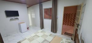 uma sala de estar com televisão e piso em azulejo em Casa aconchegante com WiFi Governador Valadares MG em Governador Valadares