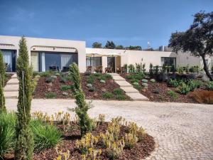 a house with a garden in front of it at Suites Sunny hill in Moncarapacho