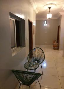 a living room with two chairs and a table at Maison d'Hôtes entière Cité Douane Golf Dakar in Dakar