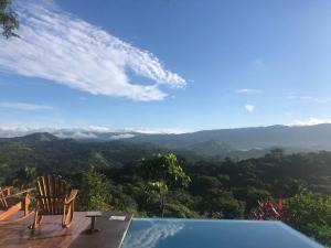 a swimming pool with a chair and a view of the mountains at Luxury Villa Carao. Jungle Paradise. Amazing Views. Great wifi! in San Mateo